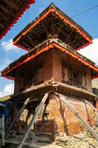 An ancient collapsing Hindu three-story temple on a stone pedestal with wooden pillars. Durbar Square in Kathmandu, Nepal
