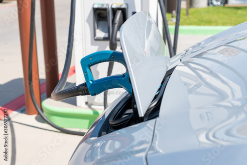 Electric car plugged in to charge battery at a charging station