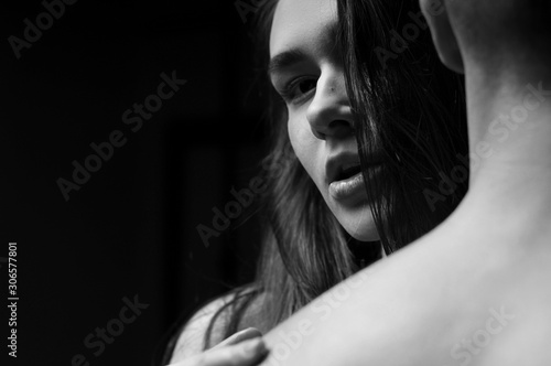 Beautiful couple embracing and fashion posing in studio