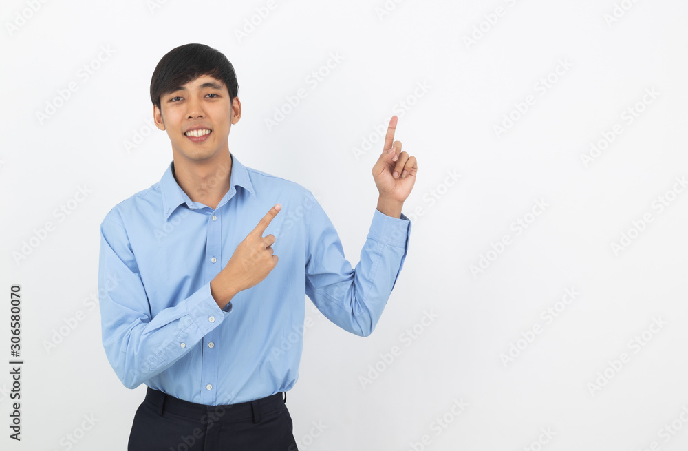 Young asian business man with blue shirt pointing to the side with a hand to present a product or an idea isolated on white background.