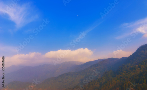 Wooded mountain slopes are covered with haze.