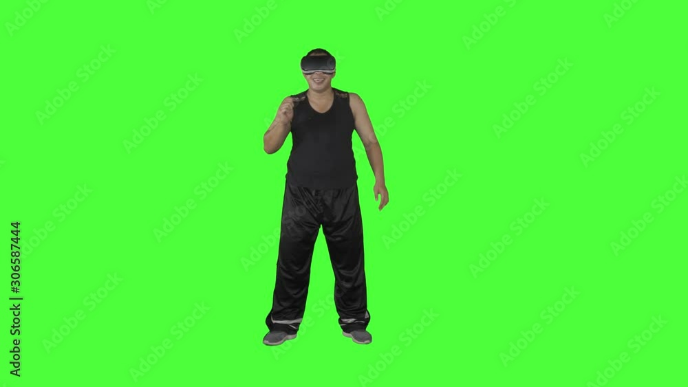 Young man dancing in the studio while wearing virtual reality glasses. Shot in 4k resolution with green screen background Young man dancing in the studio while wearing virtual reality glasses. Shot in 4k resolution with green screen background