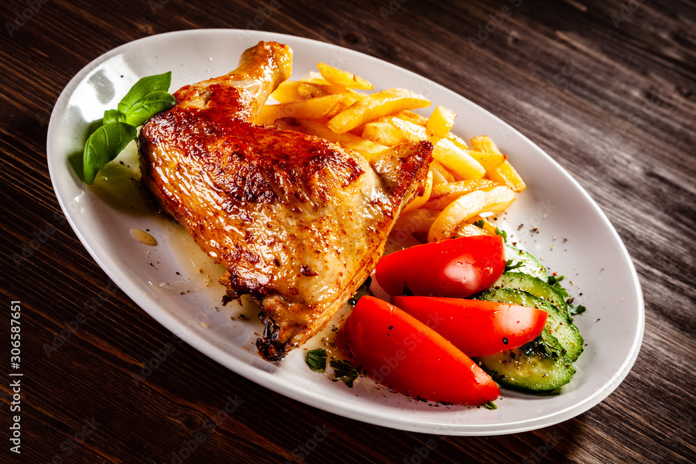 Roast chicken leg with french fries and vegetable salad Roast chicken leg with french fries and vegetable salad