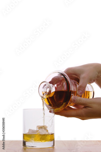 whiskey on the rocks - being poured into a glass from a whiskey decanter