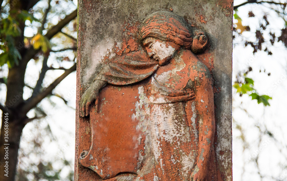 Monument and candles in the cemetery. All Saints Day in Poland. Stone sculpture. Stone angel. Monument and candles in the cemetery. All Saints Day in Poland. Stone sculpture. Stone angel.