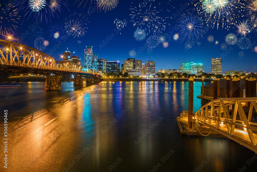 Flashing Fireworks celebrating New Years Eve in Downtown Portland with water reflection in the Willamette River, Oregon, USA
