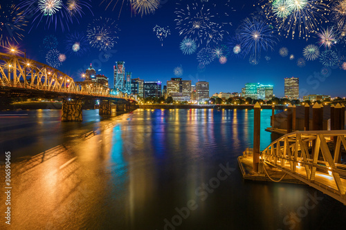 Flashing Fireworks celebrating New Years Eve in Downtown Portland with water reflection in the Willamette River, Oregon, USA
