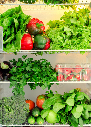 Greens, fruits and vegetables in fridge. Vegan, raw, healthy lifestyle concept