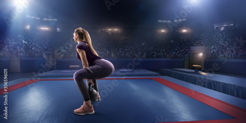 Female athlete squats with a weight on a professional stadium. Stadium and crowd are made in 3d.