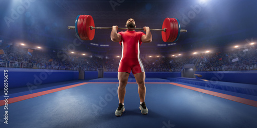 Male athlete is lifting a barbell on a professional stadium. Stadium and crowd are made in 3d.