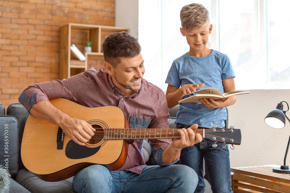 Obraz premium Father and his little son with guitar at home