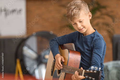 Little boy playing guitar a...