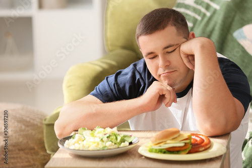 Overweight man choosing bet...