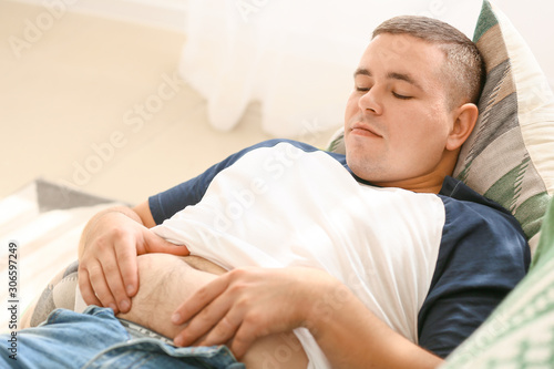 Overweight man lying on sof...