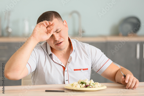 Overweight man crying while...