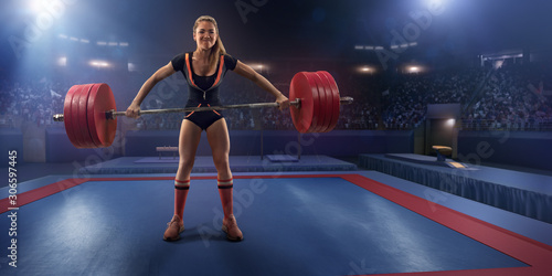 Female athlete is lifting a barbell on a professional stadium. Stadium and crowd are made in 3d.