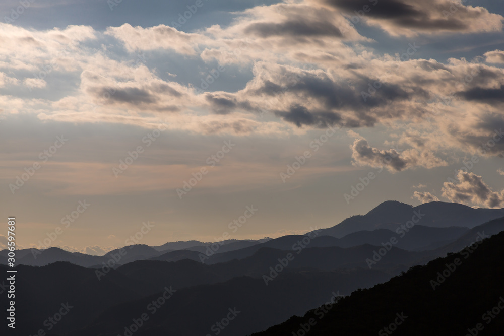 dramatic clouds in the mountains of the dominican republic with fading hills in background