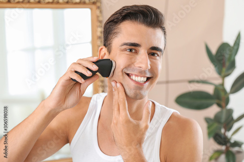 Handsome young man shaving ...