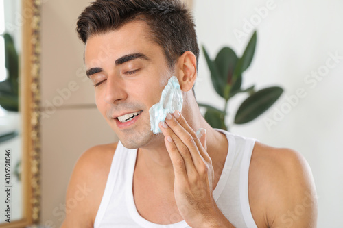 Handsome young man shaving ...