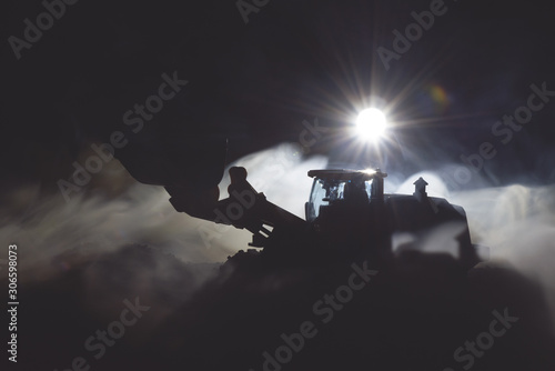 Tractor is working on the construction site at night concept.