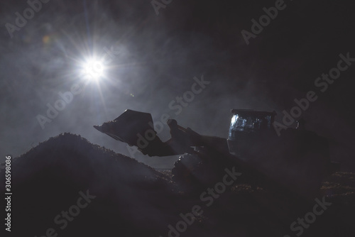 Tractor is working on the construction site at night concept.