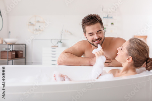Obraz na plátně Beautiful young woman spending time with her husband while taking bath