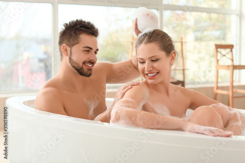 Happy young couple taking bath together