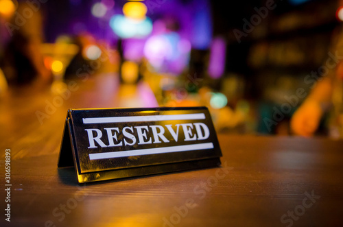 Plastic reserved plate on an arranged restaurant table photo