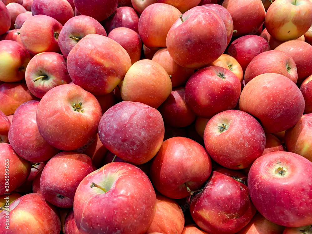 Many beautiful fresh juicy red apples in a box in a supermarket as a background Many beautiful fresh juicy red apples in a box in a supermarket as a background