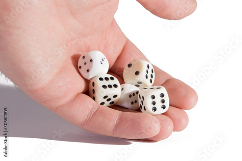 Man's hand holding playing dices. Isolated on white. Close-up of a human hand holding five dice