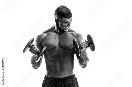 Foto Studio portrait of handsome topless bodybuilder doing exercise on biceps against white background