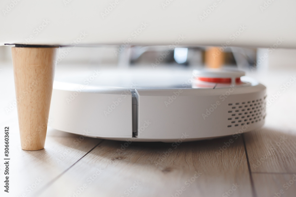 Robot vacuum cleaner vacuuming under the bed Robot vacuum cleaner vacuuming under the bed
