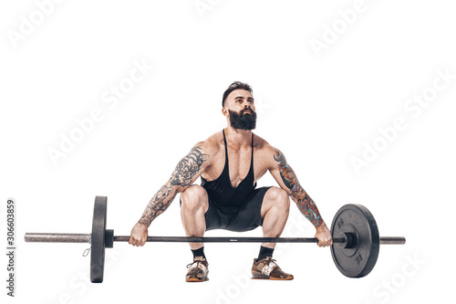 The technique of doing an exercise of deadlift with a barbell of a young muscular strong tattooed bearded sports men on a white studio background. Isolate