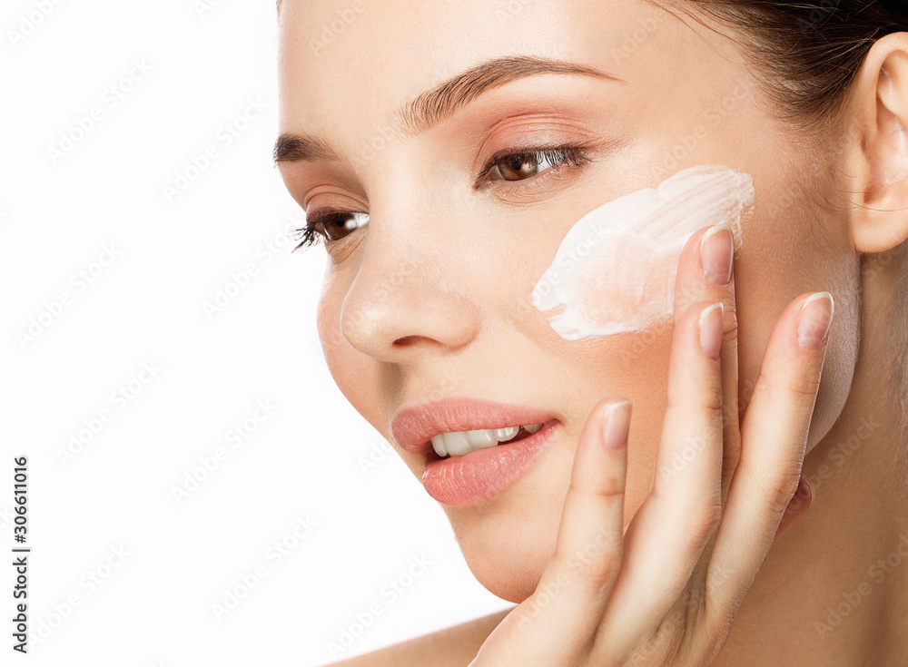 Young woman with moisturizing facial mask on white background. 