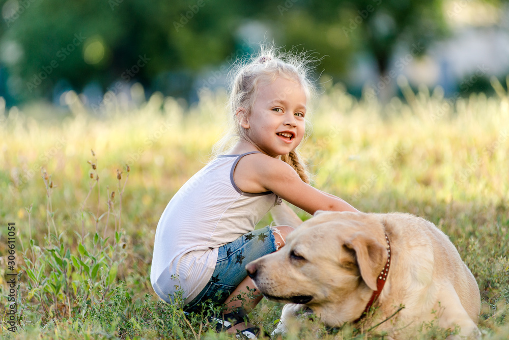 Little girl is playing with a labrador in the park. Little girl is playing with a labrador in the park.