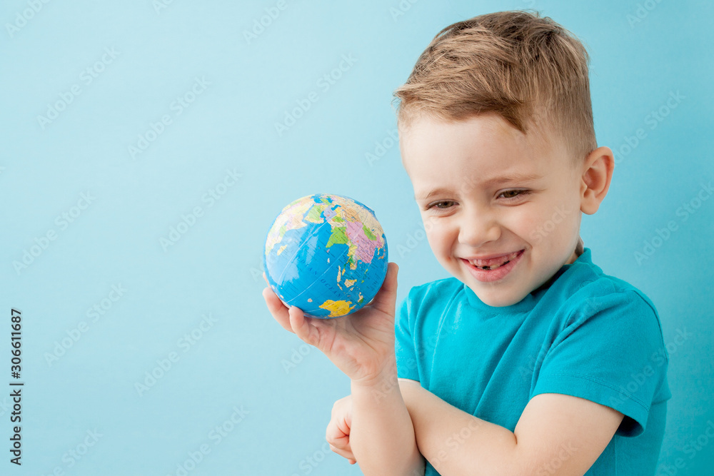 Little boy holding a globe on blue background Little boy holding a globe on blue background
