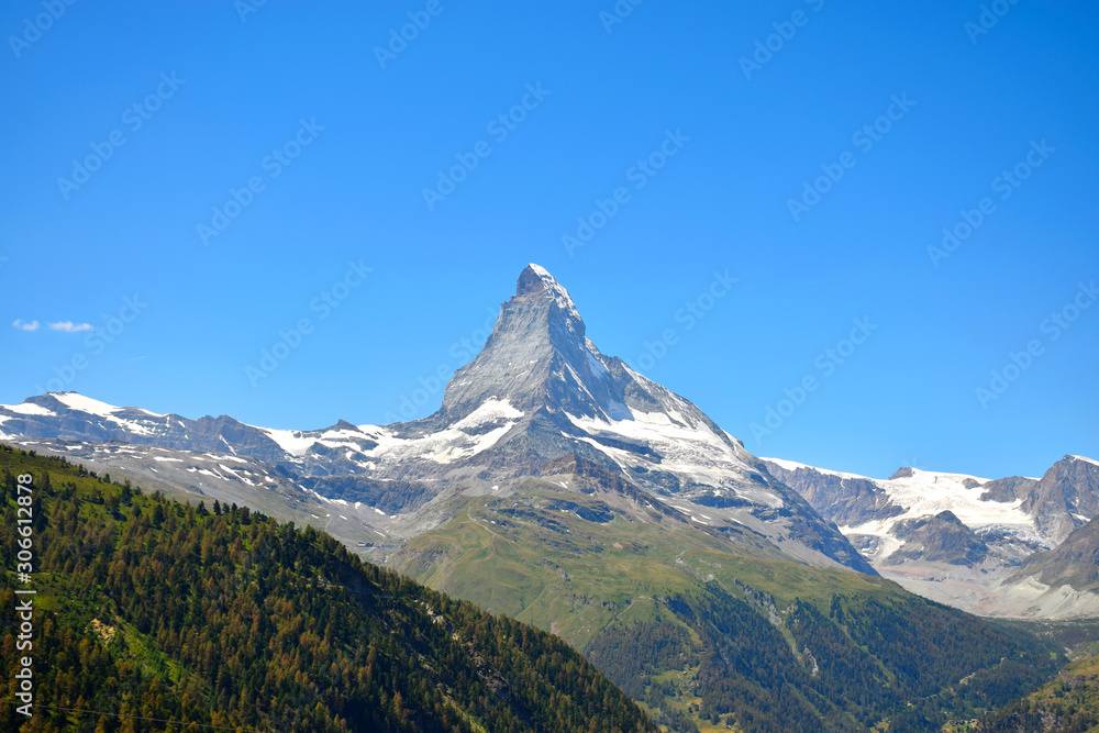 Gorgeous Matterhorn with a green and orange forest and a clear blue sky, Zermatt, Switzerland