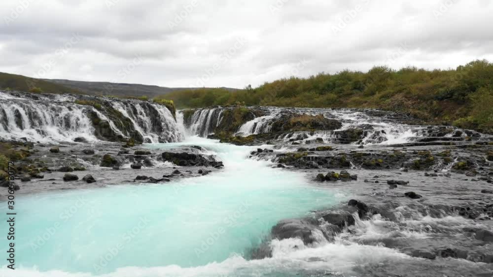 Aerial 4K video of small vivid blue waterfall cascade in Iceland Aerial 4K video of small vivid blue waterfall cascade in Iceland