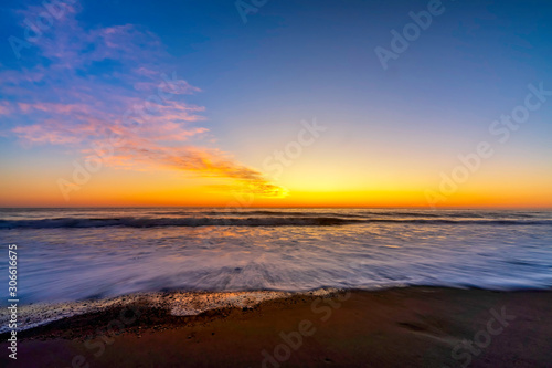 Fototapeta Naklejka Na Ścianę i Meble -  Sunset on the Beach with Waves in Ocean 