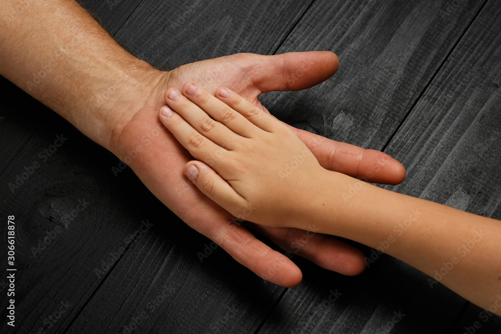 Fototapeta premium Hands of an elderly man holding the hand of child