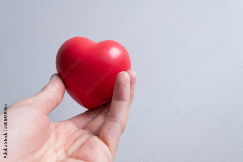 Fototapeta premium One red heart was hand in one hand. Take care of your health and heart.