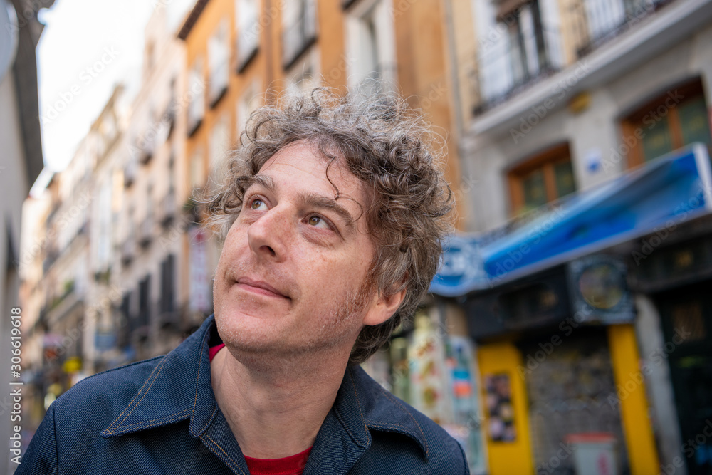 A man travels in Madrid Spain, with the beautiful cityscape and traditional Spanish architecture blurry behind. A man travels in Madrid Spain, with the beautiful cityscape and traditional Spanish architecture blurry behind.
