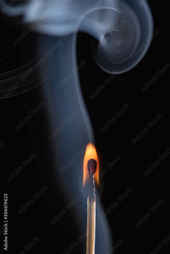 Match with blue smoke with black background Match with blue smoke with black background