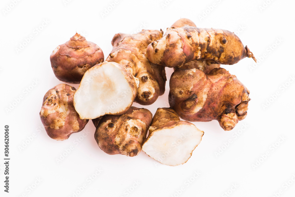 Raw Whole ans sliced Jerusalem artichokes on a white background