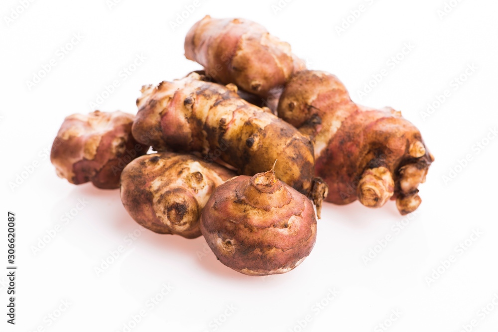 Raw Whole ans sliced Jerusalem artichokes on a white background Raw Whole ans sliced Jerusalem artichokes on a white background