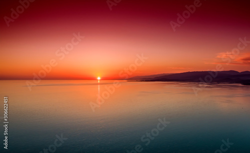 Sunset over a calm sea from the height of bird flight