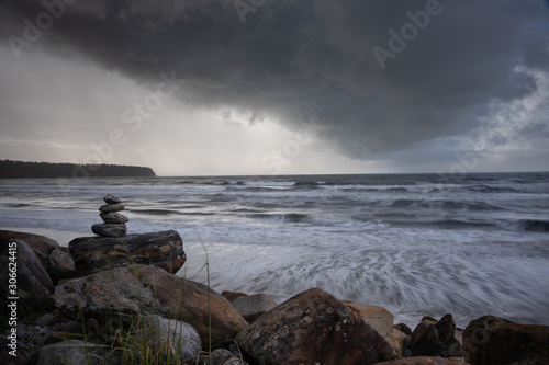Balanced stone stacks against a stormy seascape