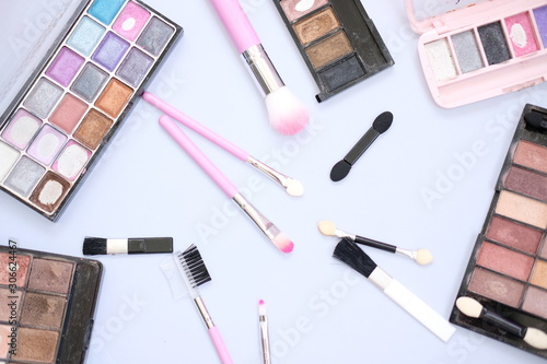 makeup set with brushes and shadows on white background