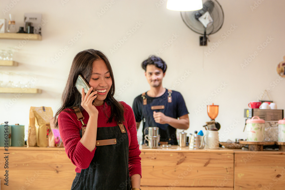 Portrait of a smiling young Asian female entrepreneur standing with her smartphone or cellphone Portrait of a smiling young Asian female entrepreneur standing with her smartphone or cellphone