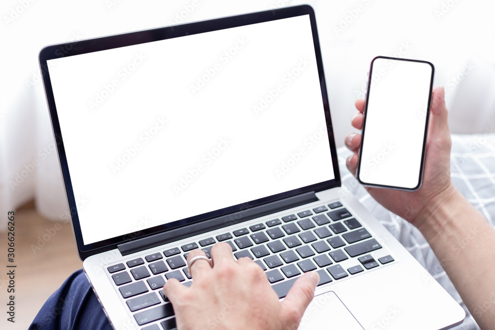 mockup image blank screen computer,cell phone with white background for advertising text,hand man using laptop texting mobile contact business search information on desk in office.marketing design mockup image blank screen computer,cell phone with white background for advertising text,hand man using laptop texting mobile contact business search information on desk in office.marketing design
